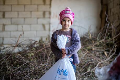 Amar, 5, holds a bag of supplies delivered by UNICEF to displaced families from South Lebanon in December 2023.